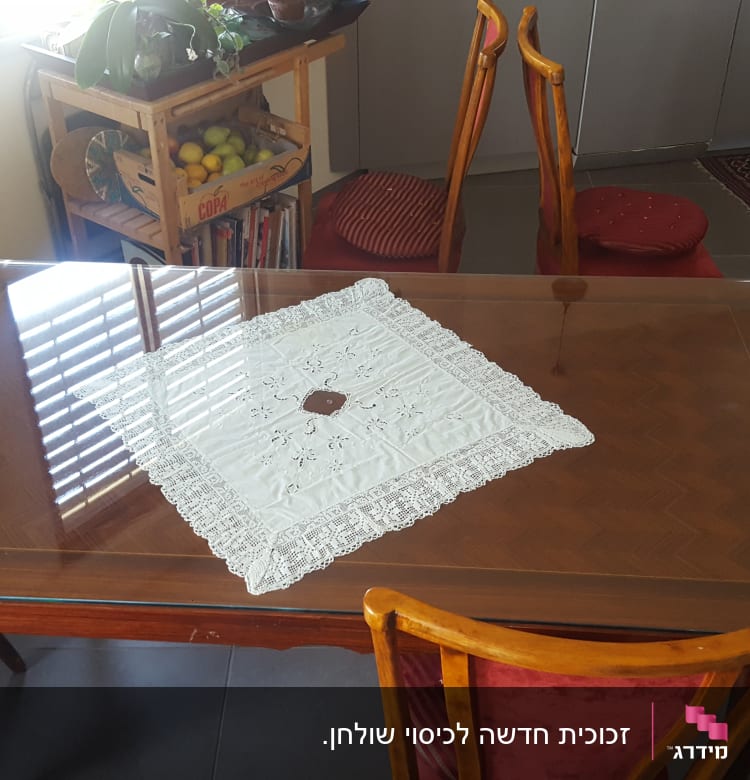 שולחן עץ עם משטח זכוכית ומפה לבנה